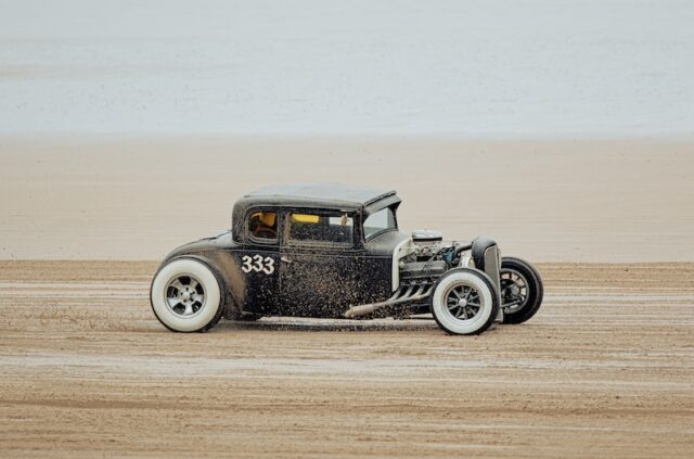 an old model t car driving on the beach
